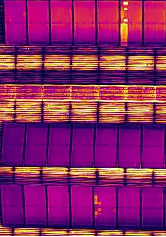 Thermal close-up of the same panels: most modules show purple, one module in the top row shows bright yellow.