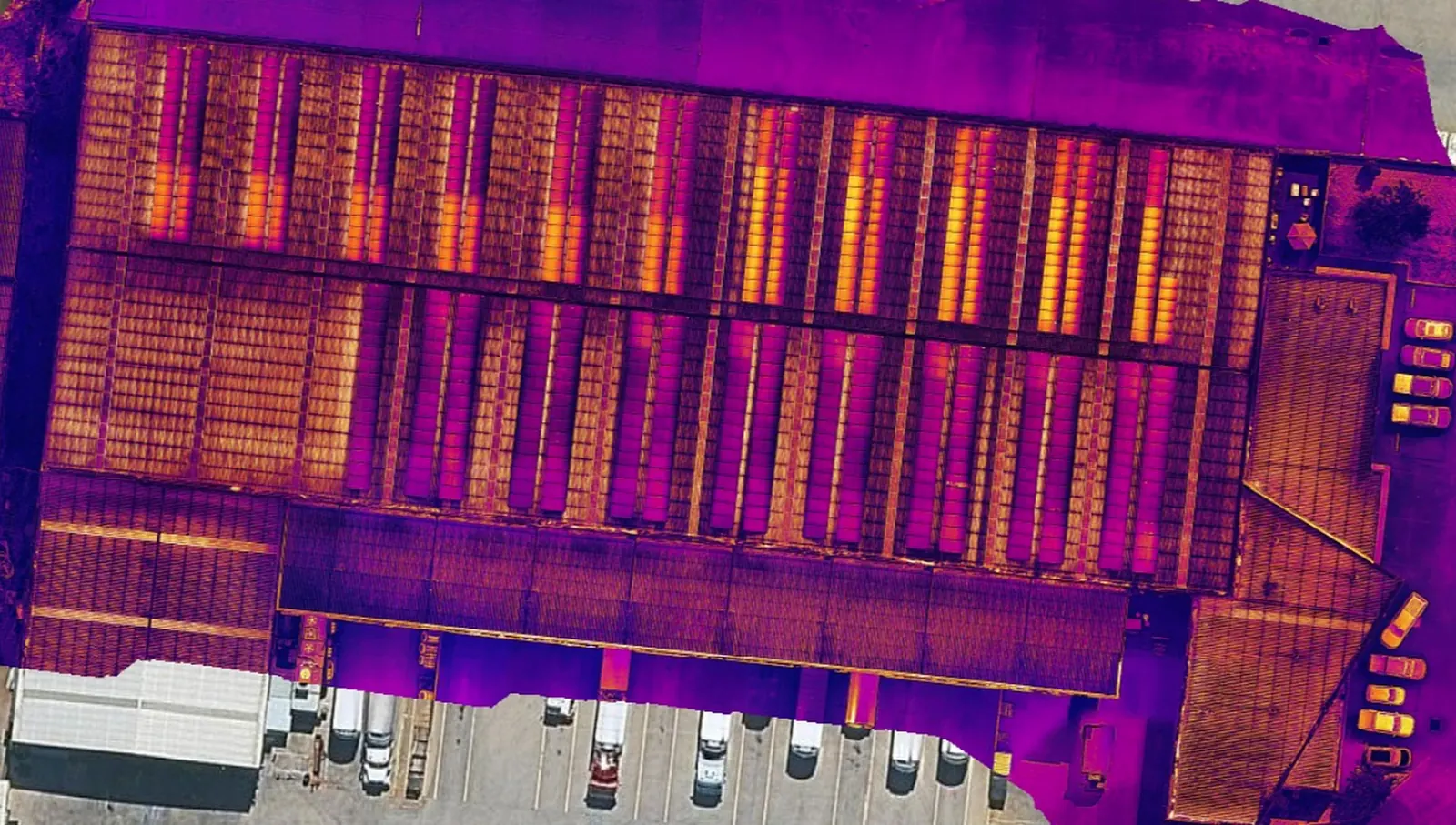 Thermal image of the same roof: some panel strings show orange and yellow, warmer than the strings beside them.