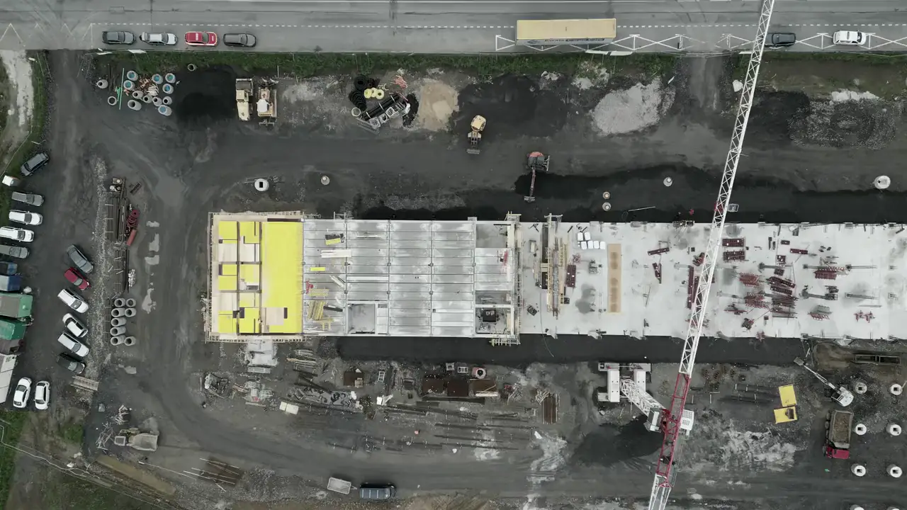 Stock aerial footage: a construction site with a crane and concrete slab works.