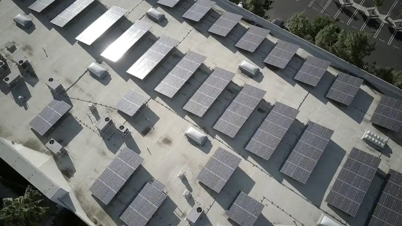 Stock aerial footage: a flat commercial roof with solar panels and air-conditioning units.